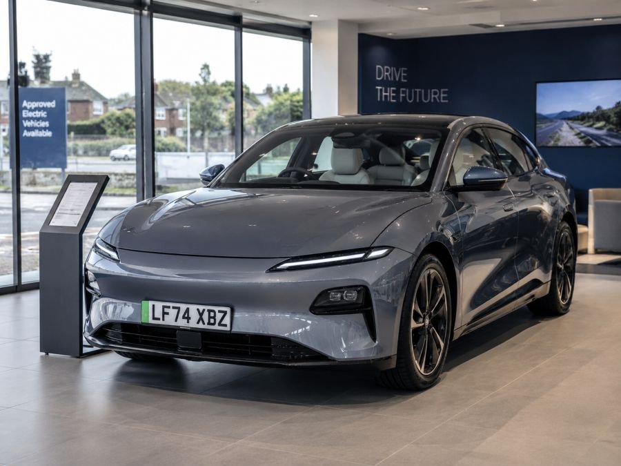 Modern Chinese electric car displayed in UK dealership with urban backdrop